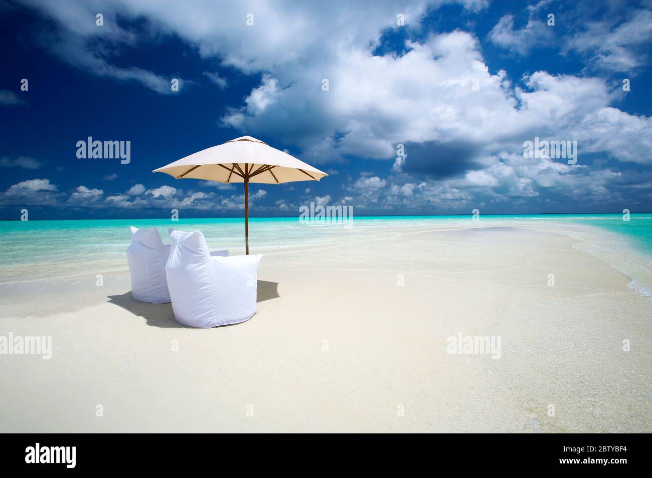 Zwei Liegestühle und Sonnenschirm am Empty Beach, den Malediven, dem Indischen Ozean, Asien Stockfoto