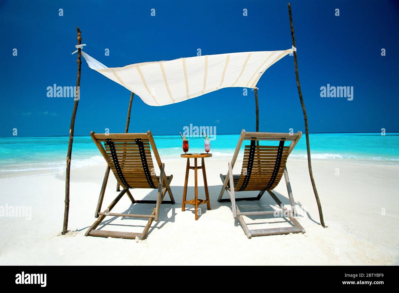 Zwei Liegestühle unter Schutz am Strand, Malediven, Indischer Ozean, Asien Stockfoto