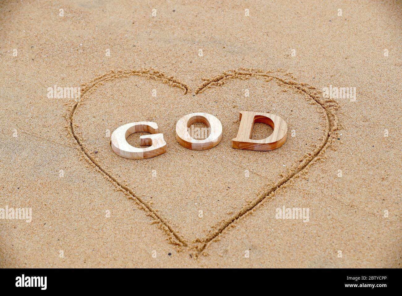 Holzbuchstaben, die das Wort GOTT mit Herz auf einem Hintergrund von Strand Sand, Christian Symbol, Vietnam, Indochina, Südostasien, Asien Stockfoto