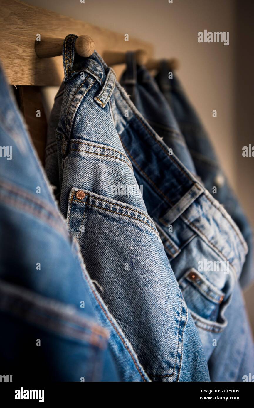 Jeans aus Denim hängen an Holzpflöcken. Stockfoto