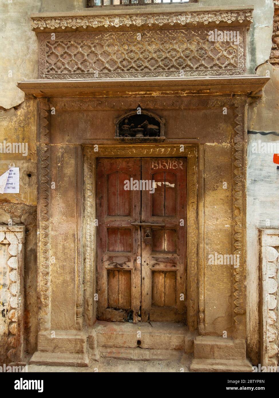 Varanasi, Uttar Pradesh, Indien - Februar 2015: Die schönen, aufwändig geschnitzten Muster am Eingang zu einem alten Haus. Stockfoto