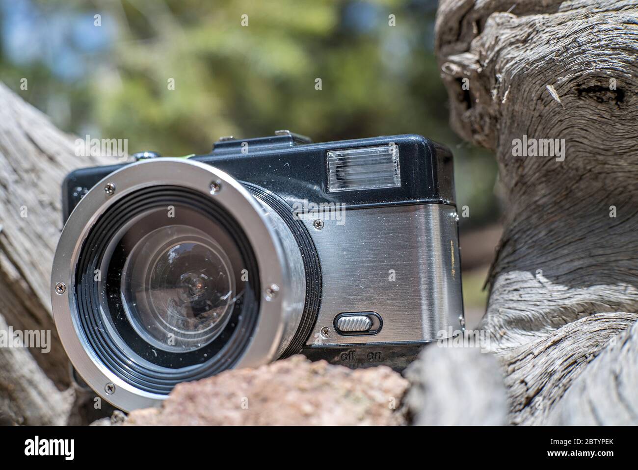 Schwarz-Silber-Lomography Fisheye II Kamera-Objektiv ruht auf einem Log während einer Pause beim Wandern Stockfoto