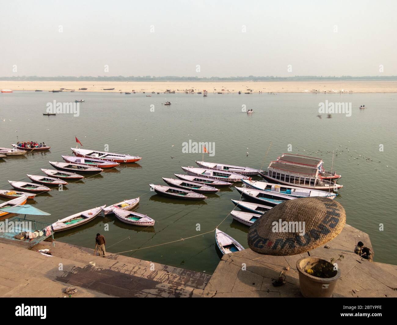 Varanasi, Uttar Pradesh, Indien - Februar 2015: Eine Luftaufnahme von hölzernen Ruderbooten auf dem Fluss Ganga neben den alten Ghats der alten Stadt. Stockfoto