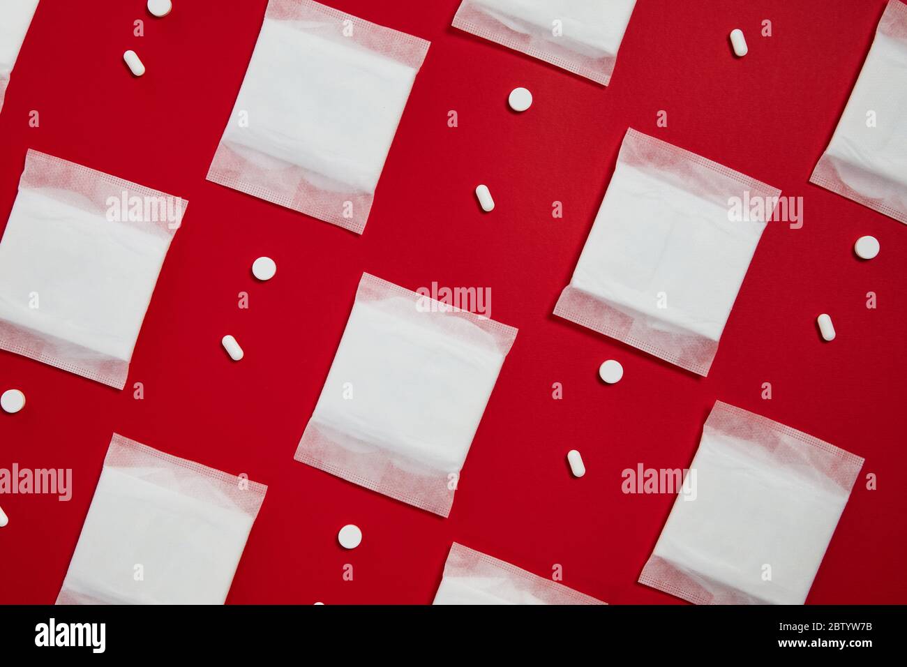 Muster mit Damenhygiene Menstruationswatte und Pillen auf rotem Hintergrund. Stockfoto
