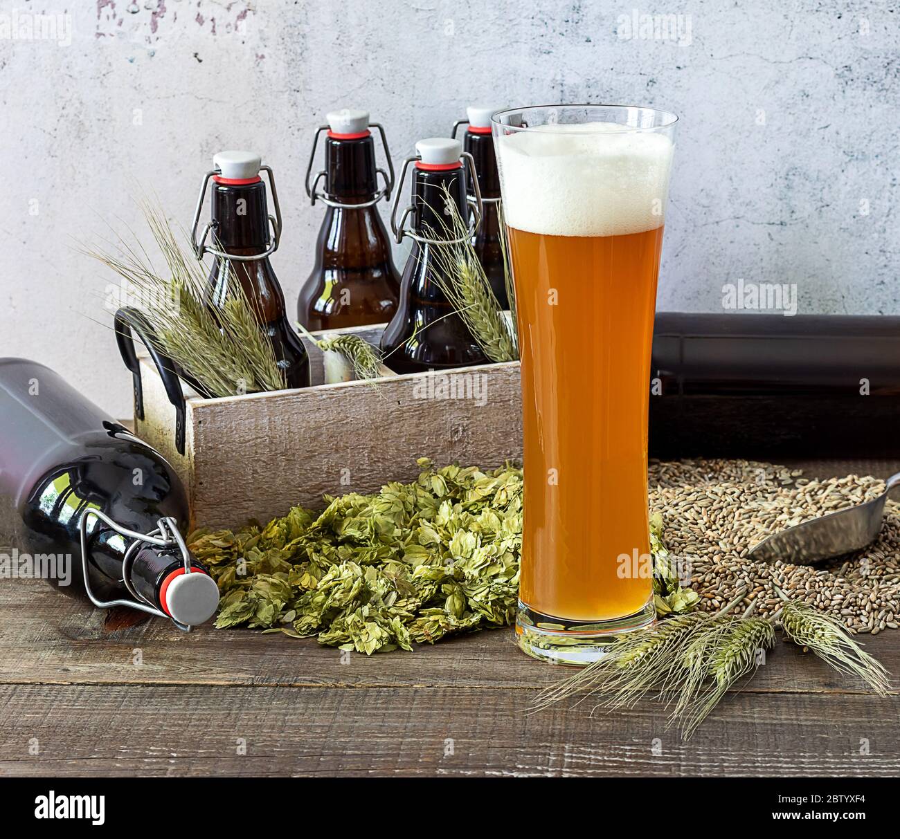Weizen Craft Bier in Hochglas mit Weizen, Hopfen und Flaschen. Stockfoto