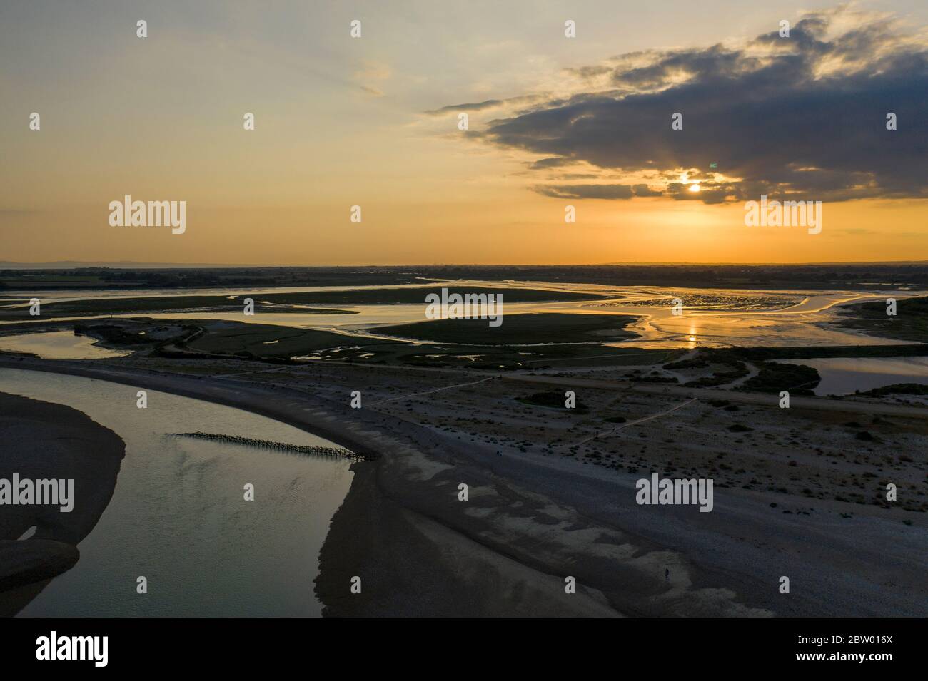 Luftaufnahme des wunderschönen Sonnenuntergangs über dem Pagham Nature Reserve mit den Farben, die vom See reflektiert werden. Stockfoto