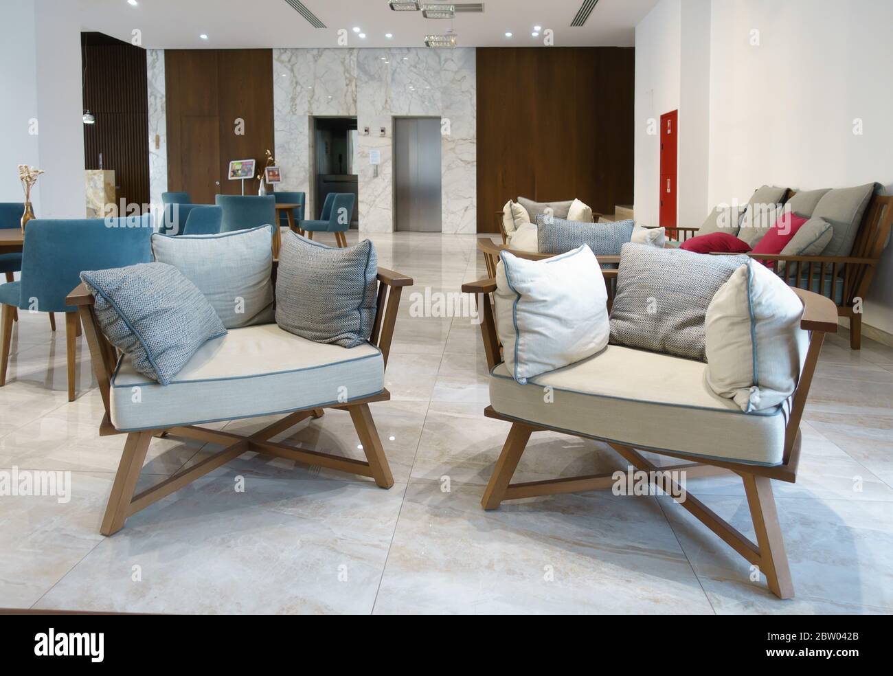 Helle Lobby des Hotels mit bequemen Sesseln und einem Tisch Stockfoto