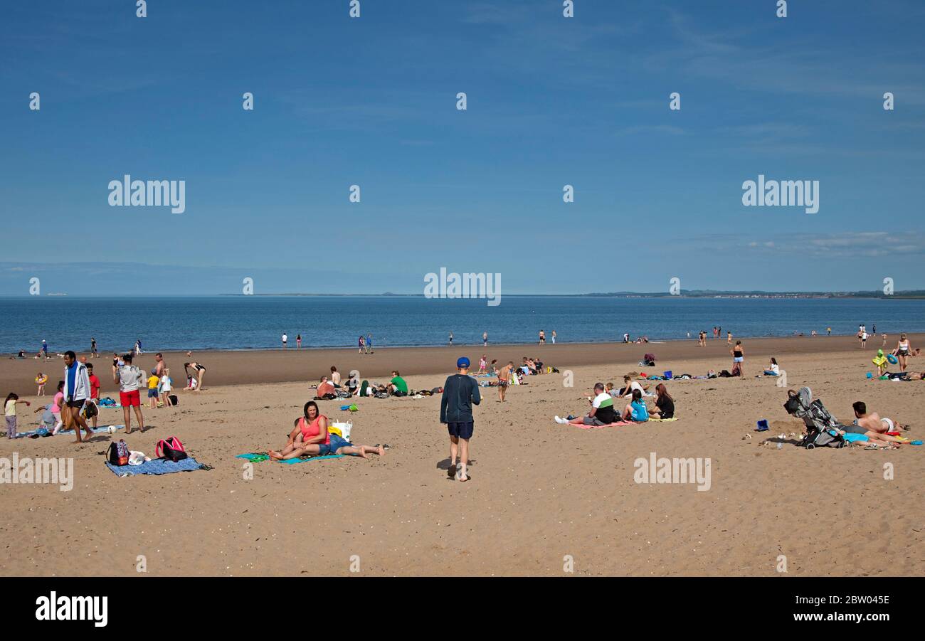 Portobello, Edinburgh, Schottland. 28 Mai 2020. 25 Grad am späten Nachmittag am Meer. Der Strand und die Promenade waren recht voll, die Polizei ging weiter, aber sie kümmerten sich nicht darum, mit jemandem über das Sitzen zu sprechen, da der schottische erste Minister einige der Einschränkungen für die schottische Öffentlichkeit lockert. Stockfoto