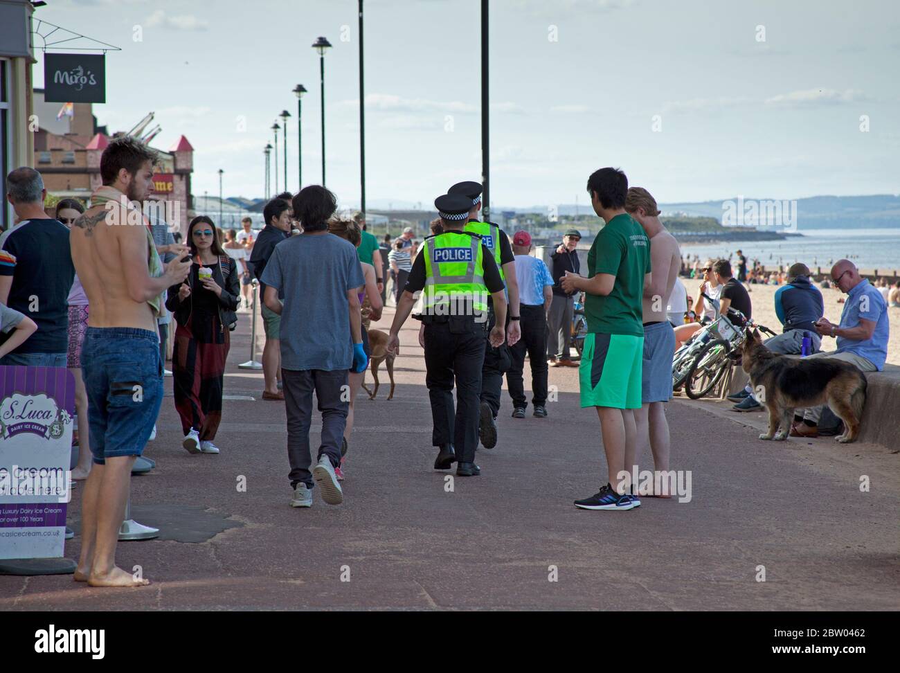 Portobello, Edinburgh, Schottland. 28 Mai 2020. 25 Grad am späten Nachmittag am Meer. Der Strand und die Promenade waren recht voll, die Polizei ging weiter, aber sie kümmerten sich nicht darum, mit jemandem über das Sitzen zu sprechen, da der schottische erste Minister einige der Einschränkungen für die schottische Öffentlichkeit lockert. Stockfoto