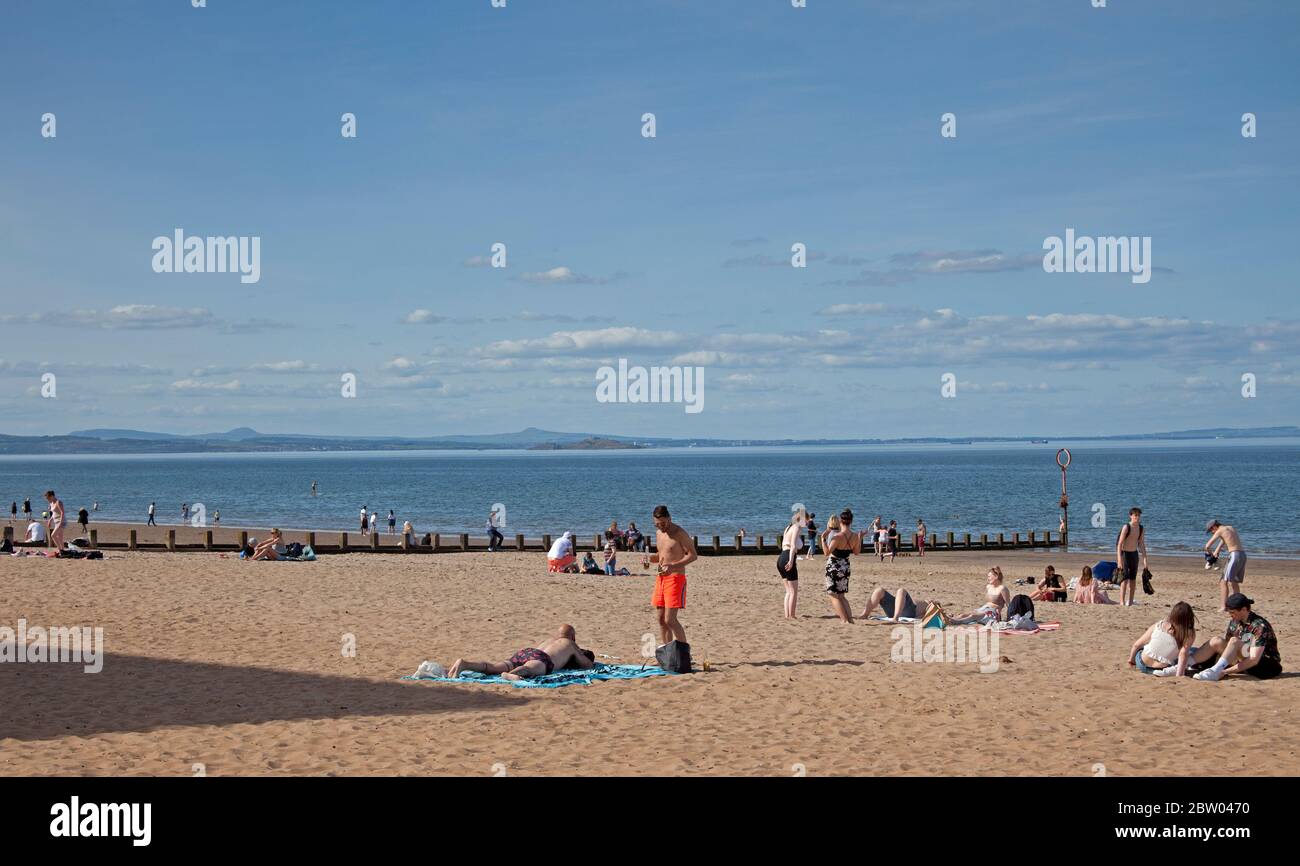 Portobello, Edinburgh, Schottland. 28 Mai 2020. 25 Grad am späten Nachmittag am Meer. Der Strand und die Promenade waren recht voll, die Polizei ging weiter, aber sie kümmerten sich nicht darum, mit jemandem über das Sitzen zu sprechen, da der schottische erste Minister einige der Einschränkungen für die schottische Öffentlichkeit lockert. Stockfoto