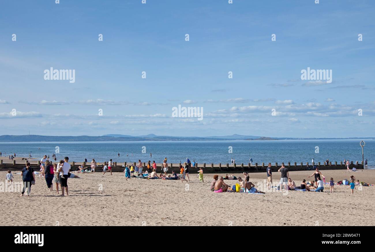 Portobello, Edinburgh, Schottland. 28 Mai 2020. 25 Grad am späten Nachmittag am Meer. Der Strand und die Promenade waren recht voll, die Polizei ging weiter, aber sie kümmerten sich nicht darum, mit jemandem über das Sitzen zu sprechen, da der schottische erste Minister einige der Einschränkungen für die schottische Öffentlichkeit lockert. Stockfoto