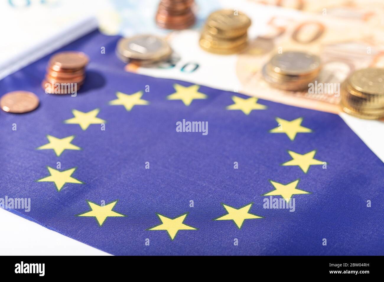 Finanzielle Anreize der Europäischen Union für das Konzept der Coronavirus Covid-19-Pandemie. Flagge der Europäischen Union mit Euro-Scheinen und -Münzen Stockfoto