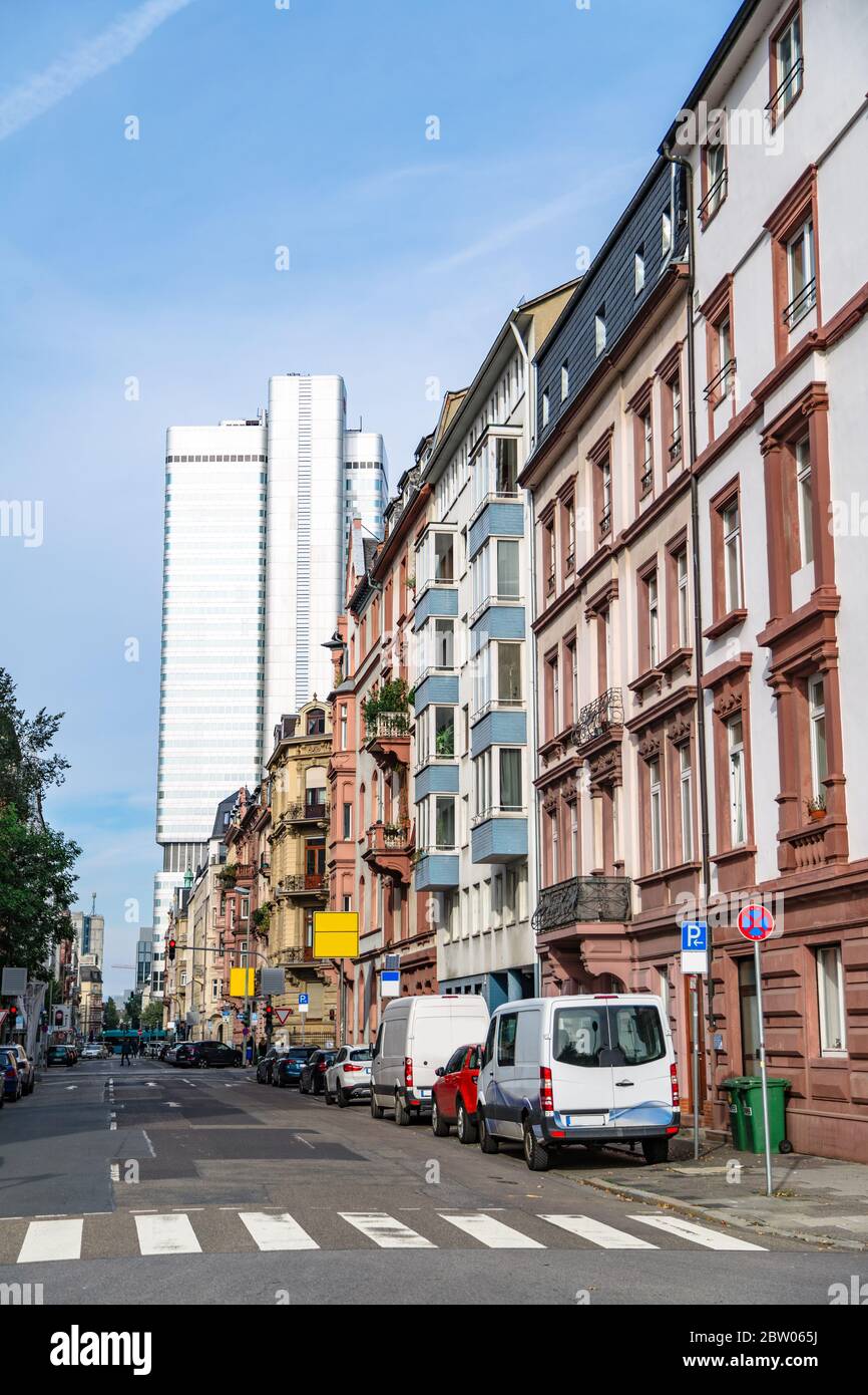 Alte Häuser auf dem Hintergrund des modernen blauen Wolkenkratzers Stockfoto