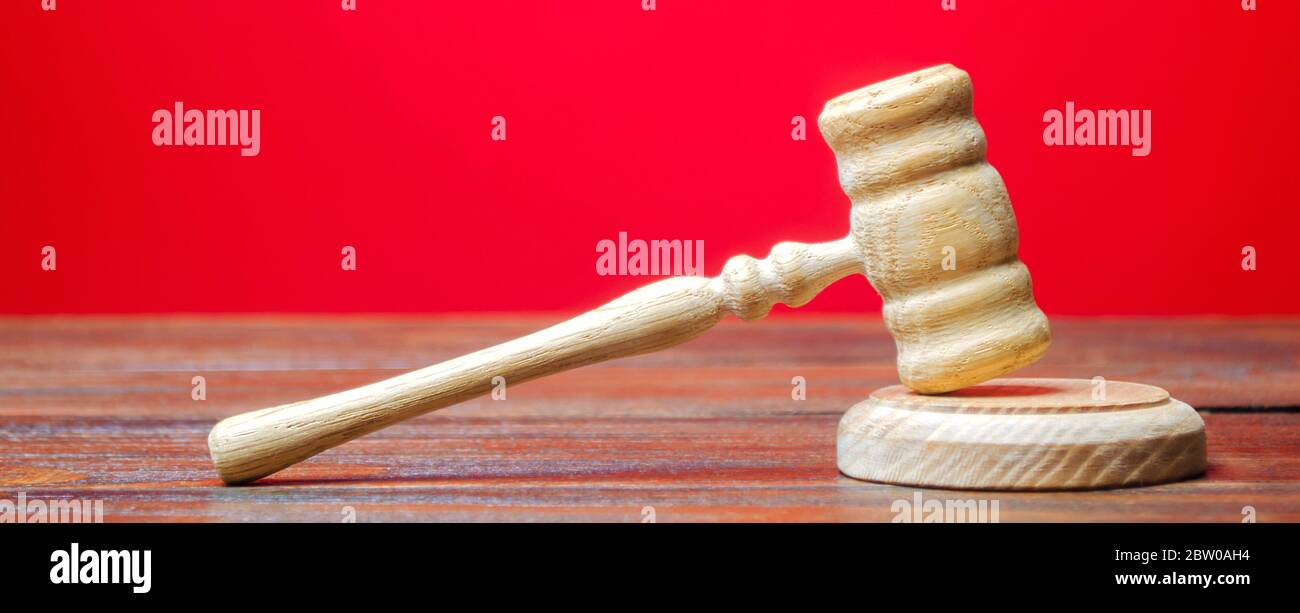 Judge's Hammer auf einem roten Hintergrund. Die Justiz. Normen, Regeln und Gesetze. Konfliktlösung bei Gericht. Gerichtsverfahren, die Beilegung von Streitigkeiten. Protectio Stockfoto