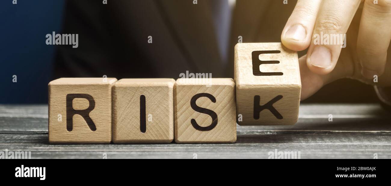 Geschäftsmann ändert Holzblöcke mit den Worten Risiko und steigen. Risikomanagement und Wachstumsleistung des Unternehmens. Risikobewertung. Planungsstrategien Stockfoto