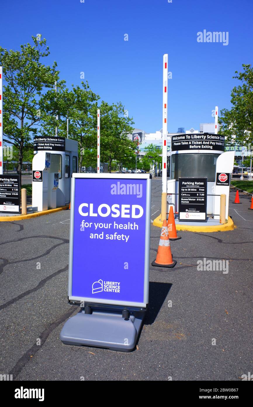 Das Zeichen für Ihre Gesundheit und Sicherheit am Eingang des leeren Parkplatzes des Liberty Science Center während des Ausbruchs der Coronavirus-Pandemie geschlossen.Liberty Science Center.Jersey City.New Jersey.USA Stockfoto