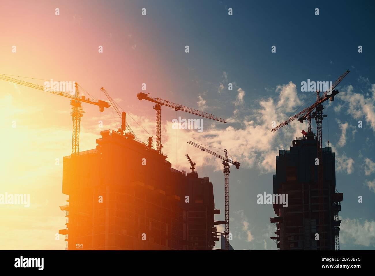 Moderne Baustelle Wolkenkratzer Gebäude mit Industriekranen arbeiten in Dubai. Schnelle Stadt- und Stadtentwicklung. Stockfoto