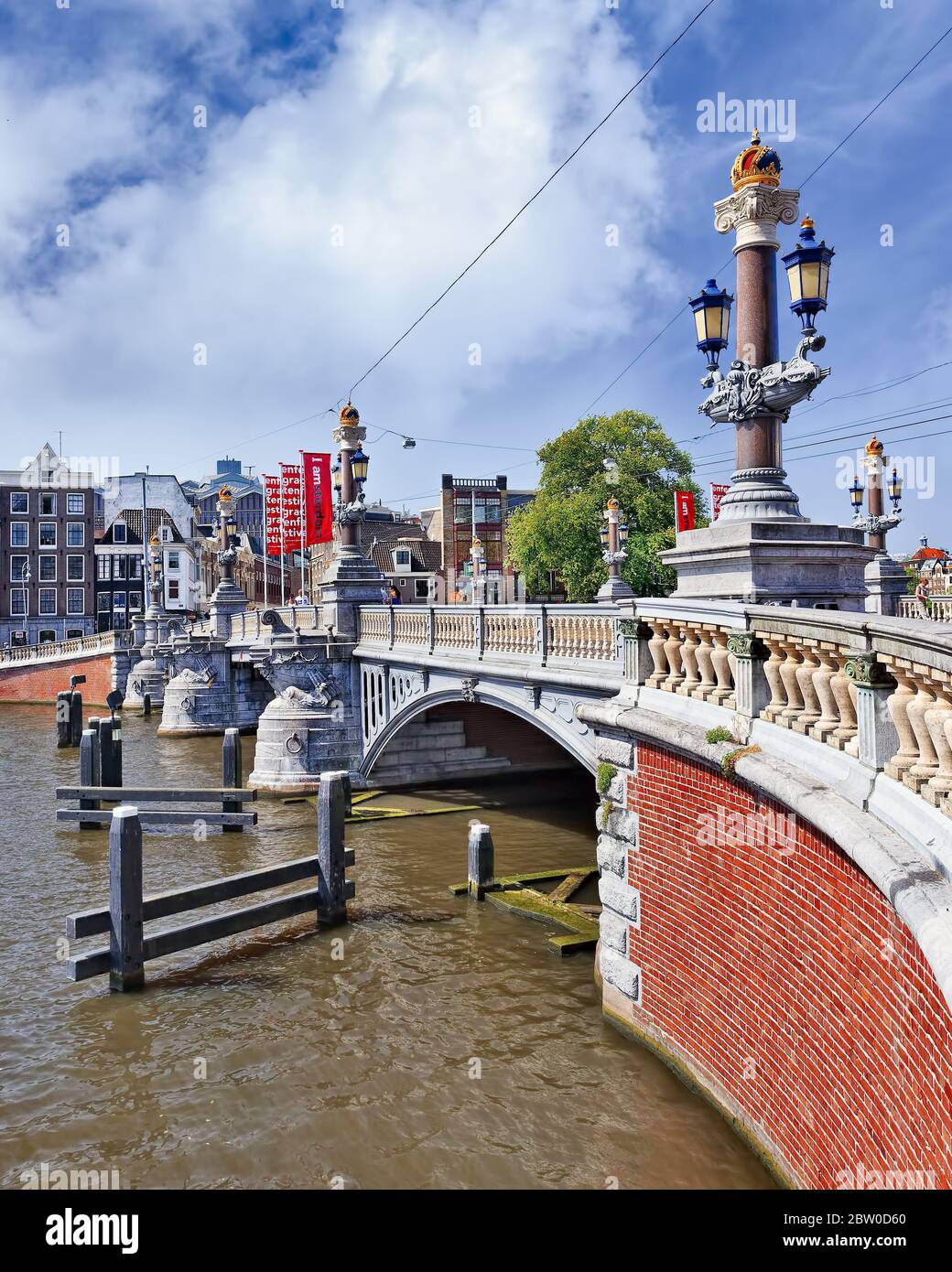 Der monumentale Blauwbrug überquert die Amstel gegen einen blauen Himmel. Es verbindet den Rembrandtplein mit dem Waterlooplein. Stockfoto