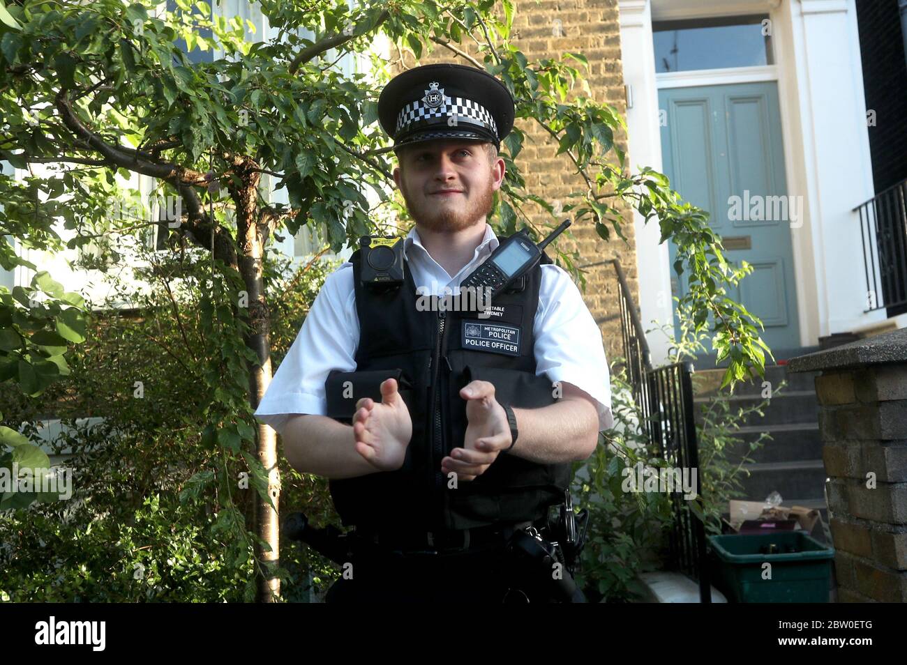 Ein Polizist vor Premierminister Boris Johnsons Top-Berater Dominic Cummings in Nordlondon, applaudiert, um lokale Helden während des landesweiten Clap für Pförter zu begrüßen, um NHS-Arbeiter und Pförter zu erkennen und zu unterstützen, die gegen die Coronavirus-Pandemie kämpfen. Stockfoto