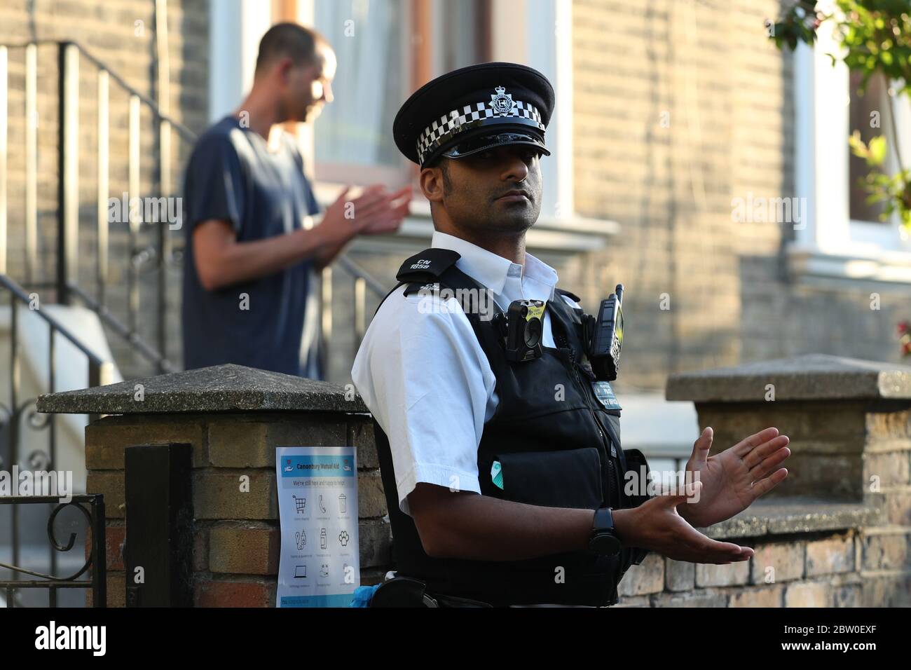 Ein Polizist vor Premierminister Boris Johnsons Top-Berater Dominic Cummings in Nordlondon, applaudiert, um lokale Helden während des landesweiten Clap für Pförter zu begrüßen, um NHS-Arbeiter und Pförter zu erkennen und zu unterstützen, die gegen die Coronavirus-Pandemie kämpfen. Stockfoto