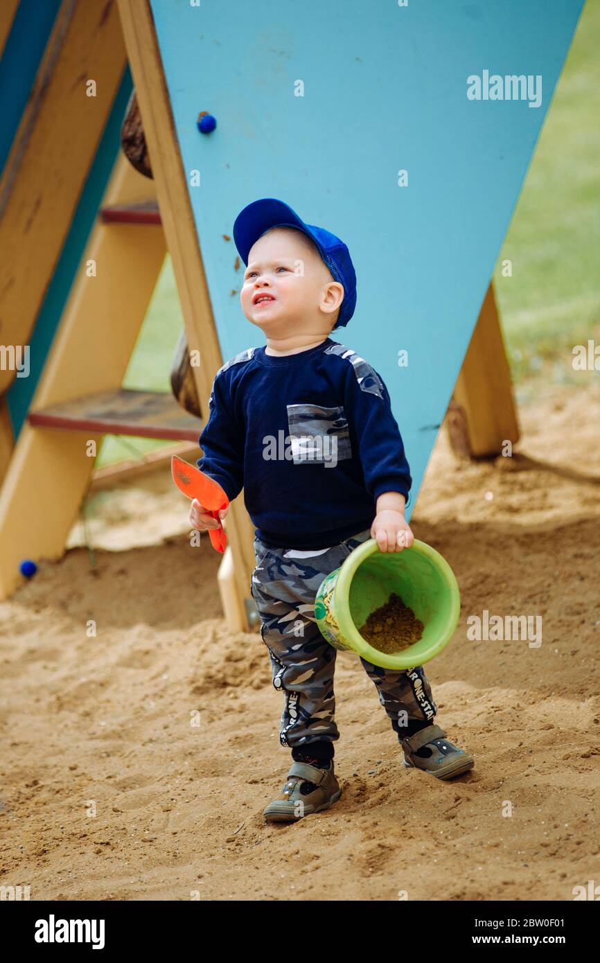 Ein Junge 1-2 Jahre alt spielt auf dem Spielplatz mit Spielzeug Stockfoto