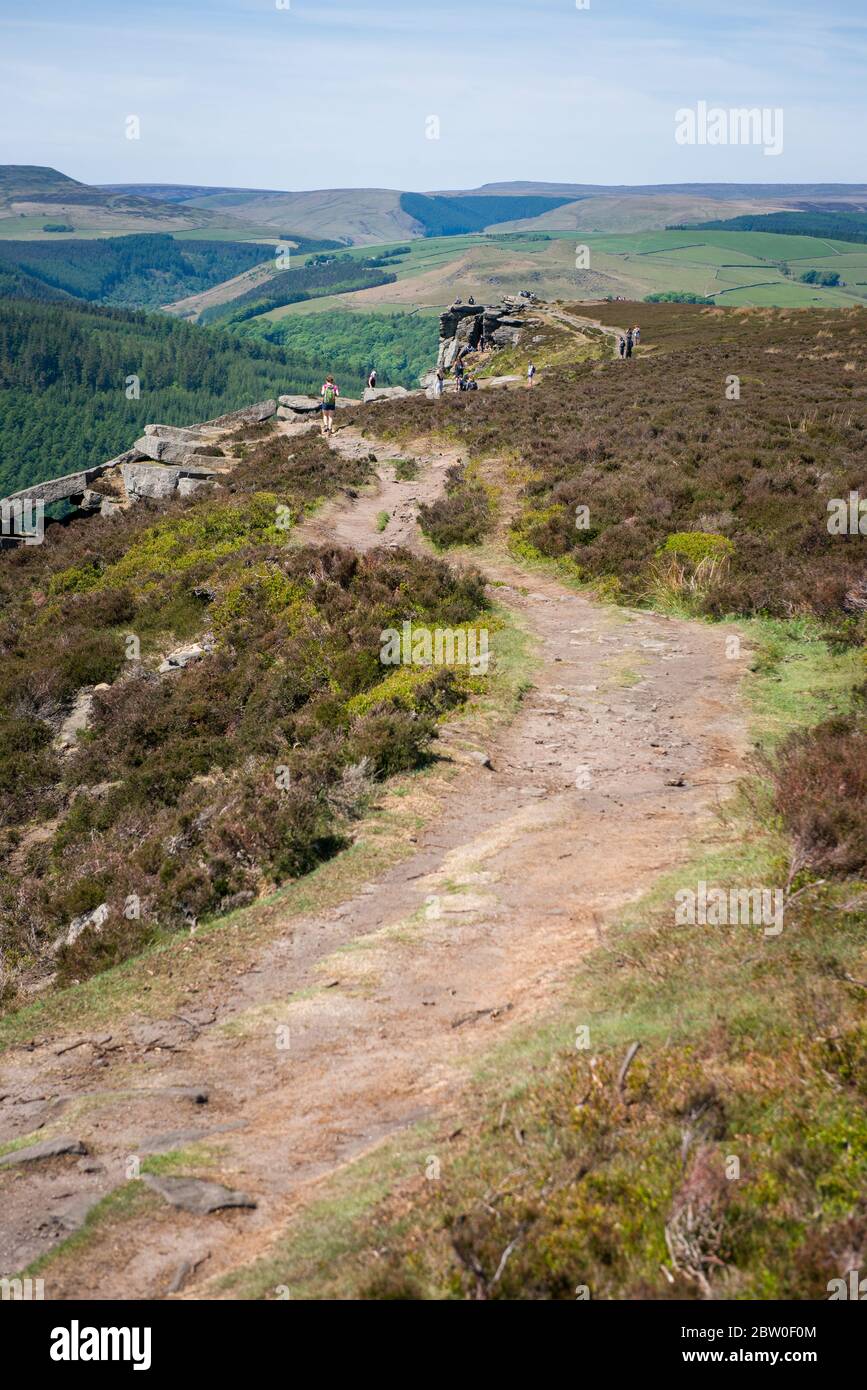 Blick von Bamford Edge in Richtung Ladybower Reservoir mit Menschen sitzen / klettern / genießen den Tag nach der Sperrung Coronavirus erleichtert wurde Stockfoto