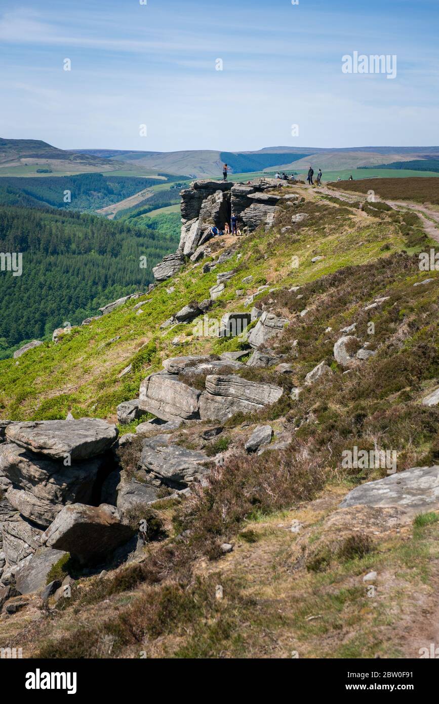 Blick von Bamford Edge in Richtung Ladybower Reservoir mit Menschen sitzen / klettern / genießen den Tag nach der Sperrung Coronavirus erleichtert wurde Stockfoto
