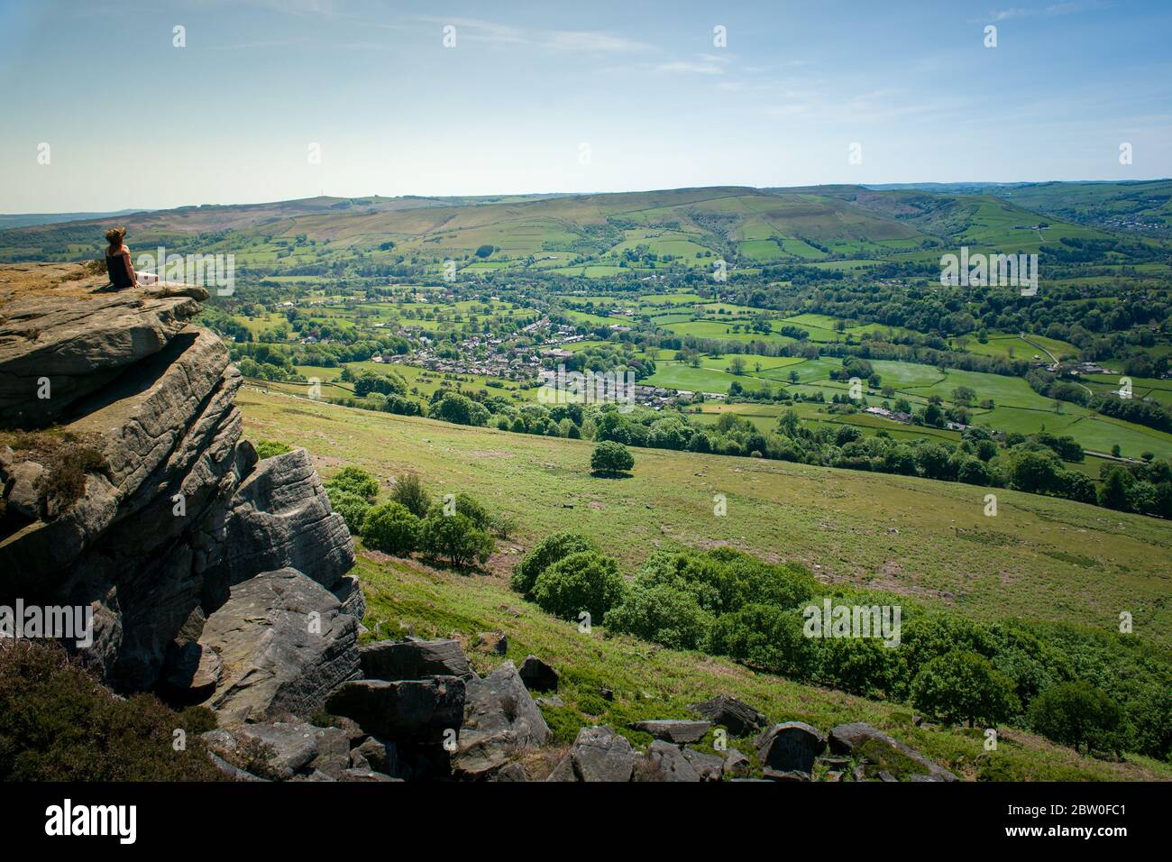 Blick von Bamford Edge in Richtung Ladybower Reservoir mit Menschen sitzen / klettern / genießen den Tag nach der Sperrung Coronavirus erleichtert wurde Stockfoto