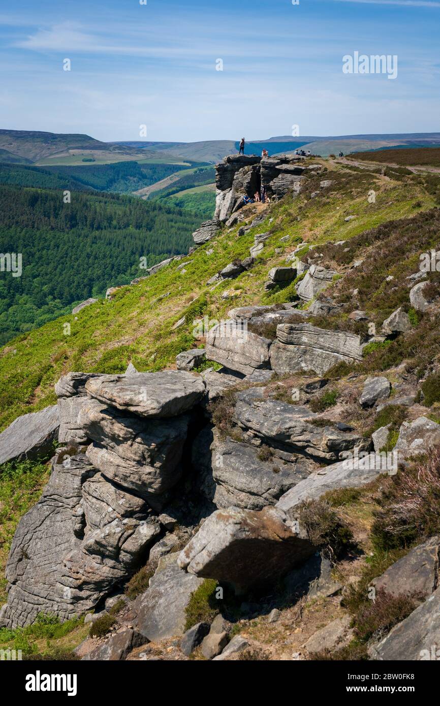 Blick von Bamford Edge in Richtung Ladybower Reservoir mit Menschen sitzen / klettern / genießen den Tag nach der Sperrung Coronavirus erleichtert wurde Stockfoto