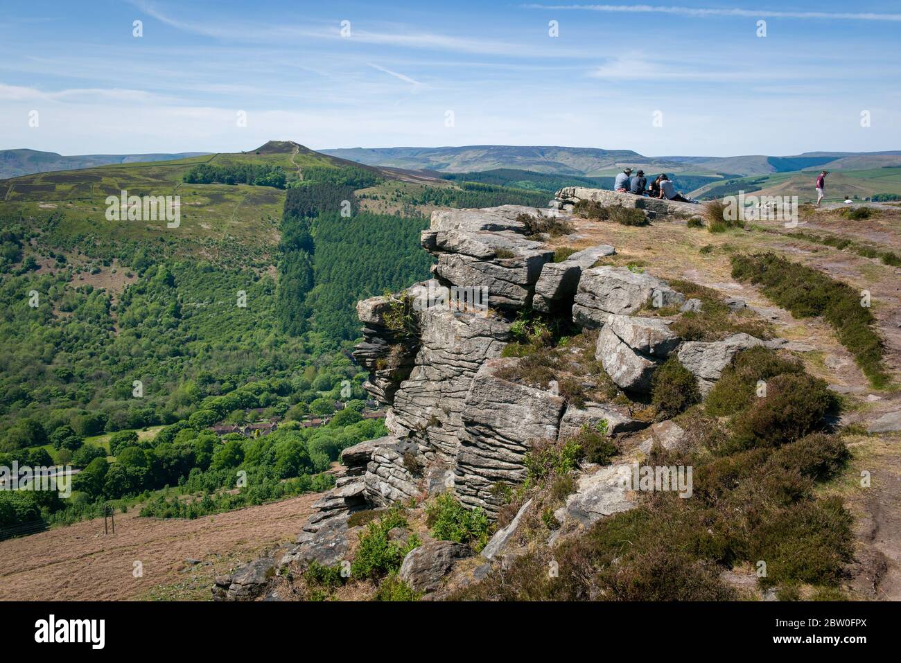 Blick von Bamford Edge in Richtung Ladybower Reservoir mit Menschen sitzen / klettern / genießen den Tag nach der Sperrung Coronavirus erleichtert wurde Stockfoto