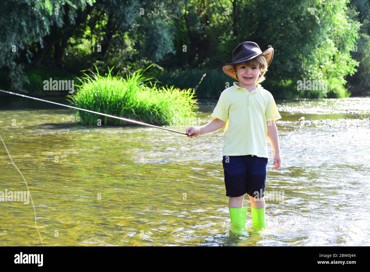 Kleiner Junge, der einen Fisch fängt. Kinder Angeln. Junge Angeln im