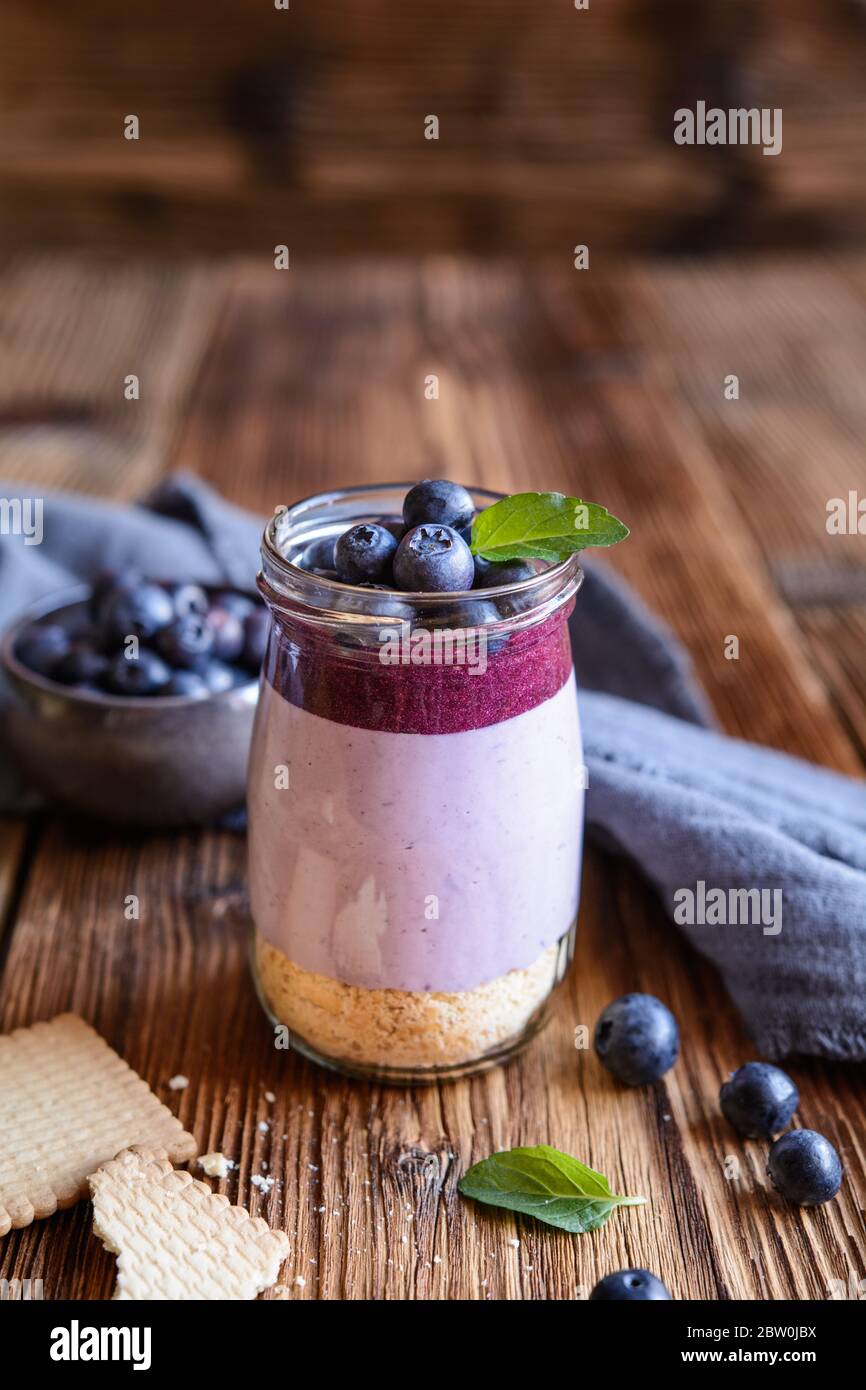 Köstlicher Heidelbeer-Käsekuchen in einem Glasgefäß Stockfoto