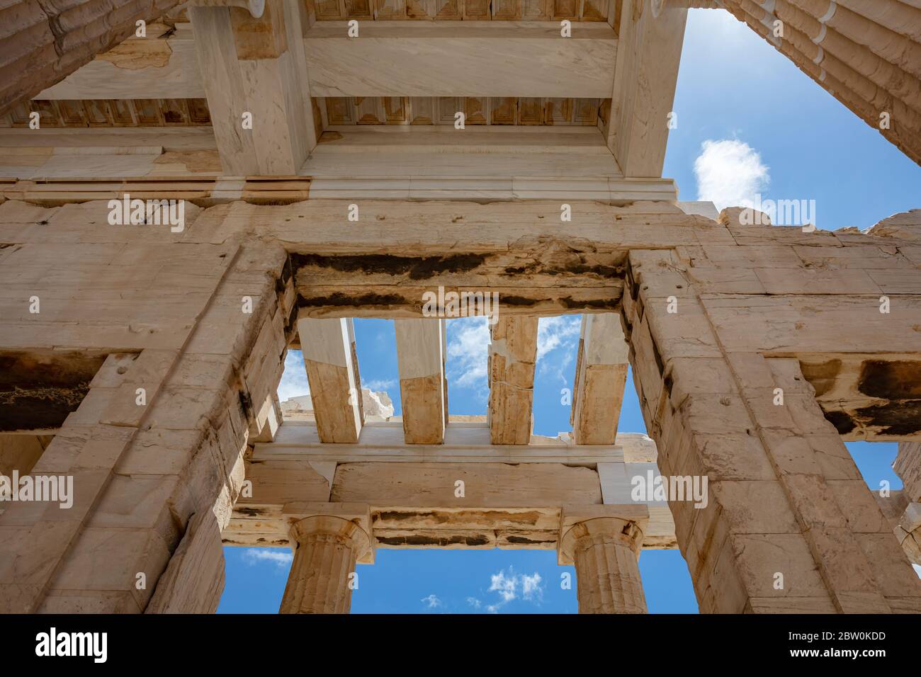 Akropolis von Athen, Griechenland Wahrzeichen. Antike griechische Propylaea Eingang Tor Decke und Säulen niedrigen Winkel Blick, blauer Himmel, Frühling sonnigen Tag. Stockfoto