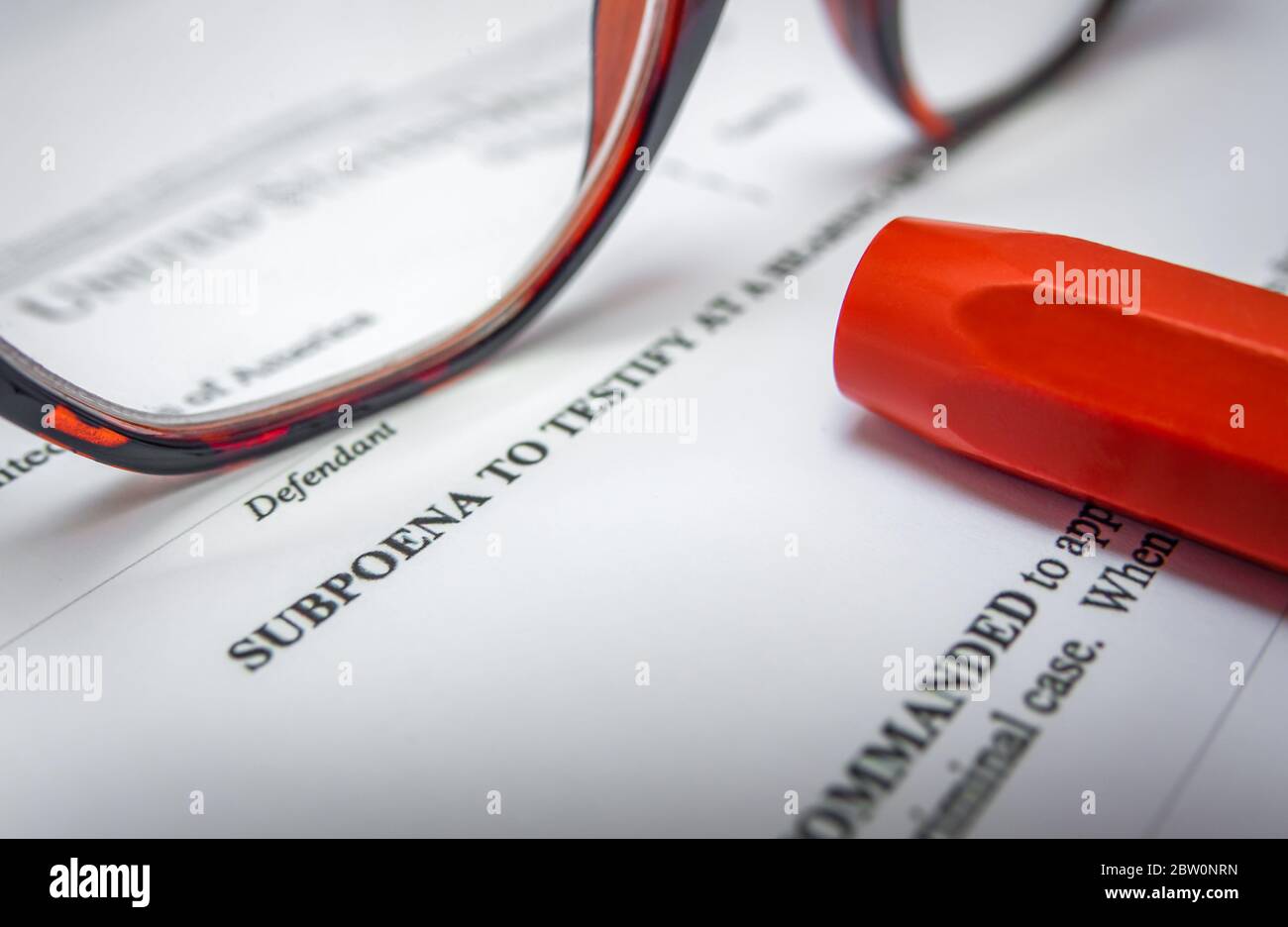 Detail einer Vorladung für EINEN Strafgerichtsfall mit Brille und einem Stift Stockfoto