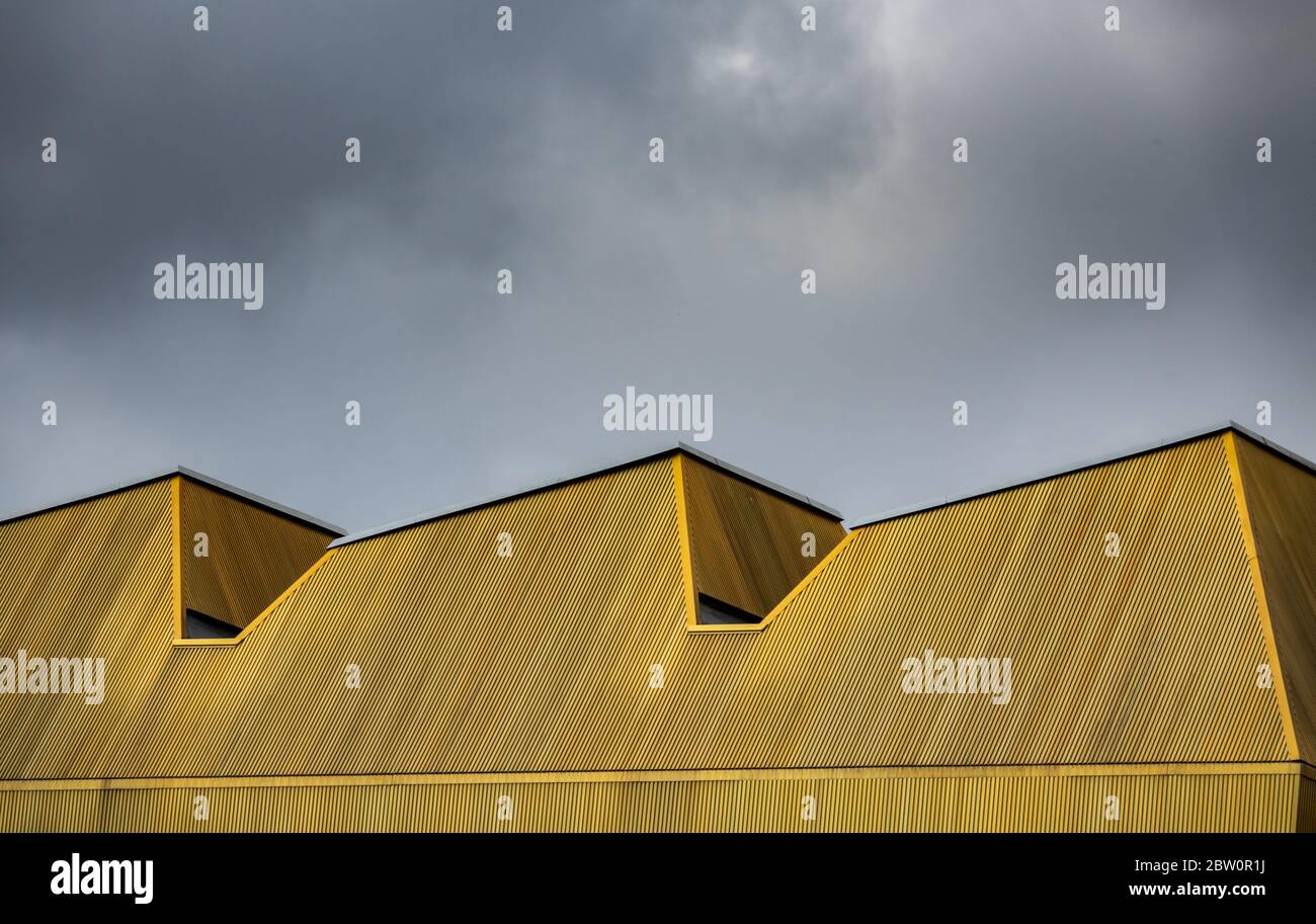 Abstrakte Architektur Bild eines urbanen modernen gelben Daches gegen EINEN wolkigen Himmel Stockfoto
