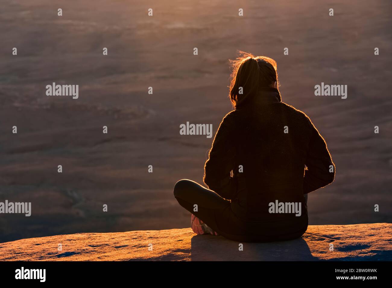 Junge Frau, die den Sonnenuntergang vom Green River aus genießt, überblicken Sie Island in the Sky im Canyonlands National Park, Utah, USA [Keine Modellfreigabe; verfügbar für ed Stockfoto