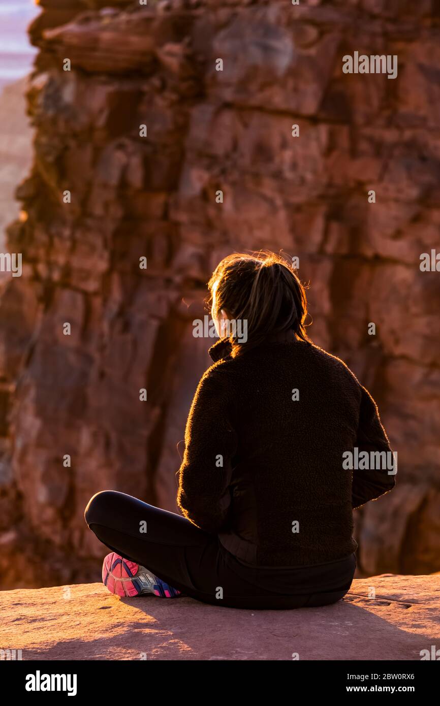 Junge Frau, die den Sonnenuntergang vom Green River aus genießt, überblicken Sie Island in the Sky im Canyonlands National Park, Utah, USA [Keine Modellfreigabe; verfügbar für ed Stockfoto