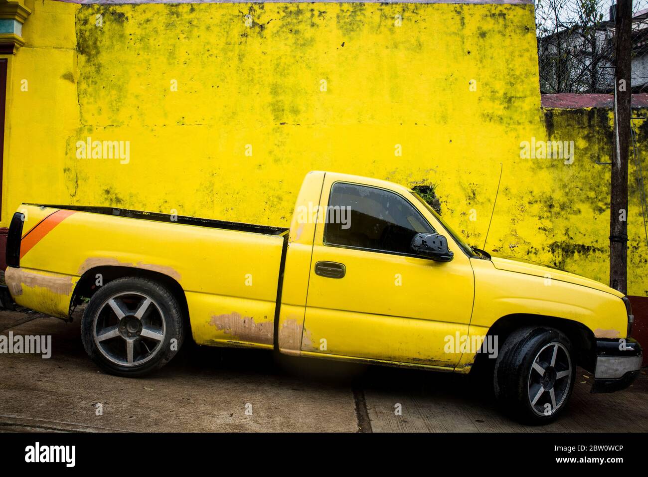 Gelber LKW vor einer gelben Wand Stockfoto