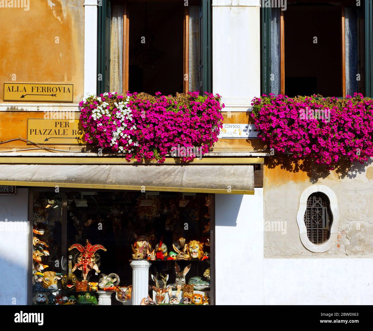 Venedig, ein Traumziel in Italien, wird einer der schönsten Städte der Welt zugeschrieben. Bunte Blumen blühen an den Fenstern. Stockfoto