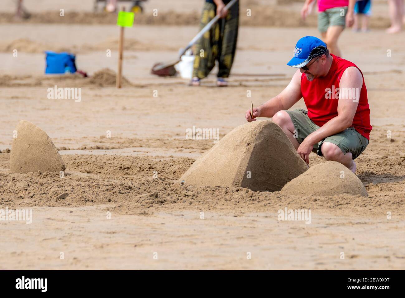 New River Beach, NB, Kanada - 27. Juli 2019: Ein Mann formt seine Skulptur mit einem Stock im Rahmen des jährlichen Sandskulptur-Wettbewerbs. Der Wettbewerb zieht an Stockfoto