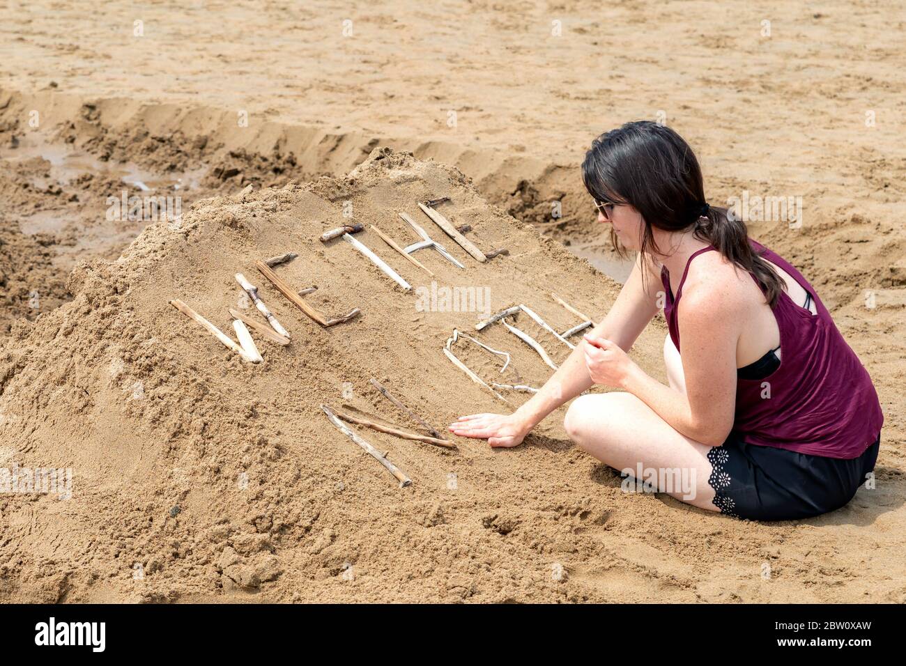 New River Beach, NB, Kanada - 27. Juli 2019: Eine Frau arbeitet an einer Sandskulptur mit dem Titel "WIR DER NORDEN" im Rahmen eines Sandskulptur-Wettbewerbs. Der Wettbewerb dr Stockfoto
