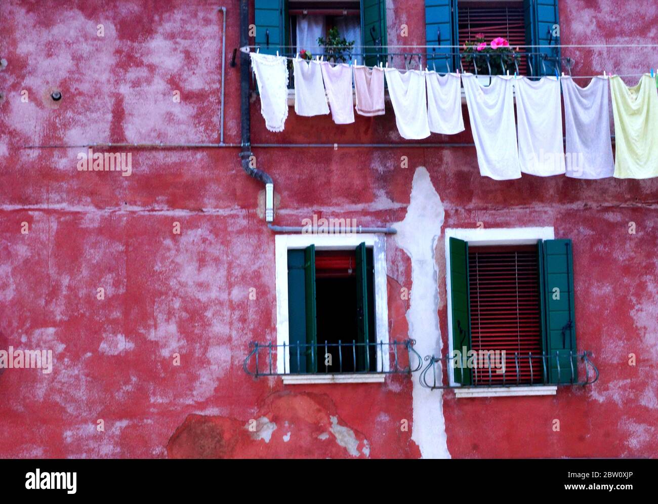 Gewaschen Tücher hängen an einer bunten Wand auf der Insel Burano, Italien, berühmt für seine exquisite Spitze Herstellung Tradition. Stockfoto