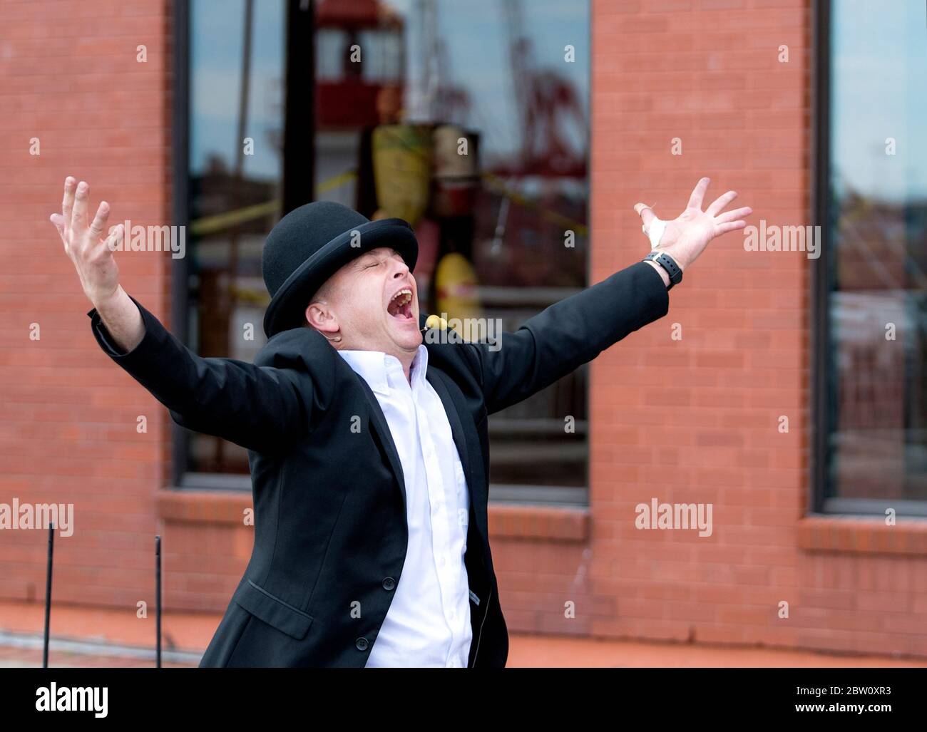 Saint John, New Brunswick, Kanada - 13. Juli 2017: Alljährliches Buskers On The Bay Festival. Ein Mann, der einen schwarzen Hut trägt, mit weit ausgebreiteten Armen, schreit. Stockfoto