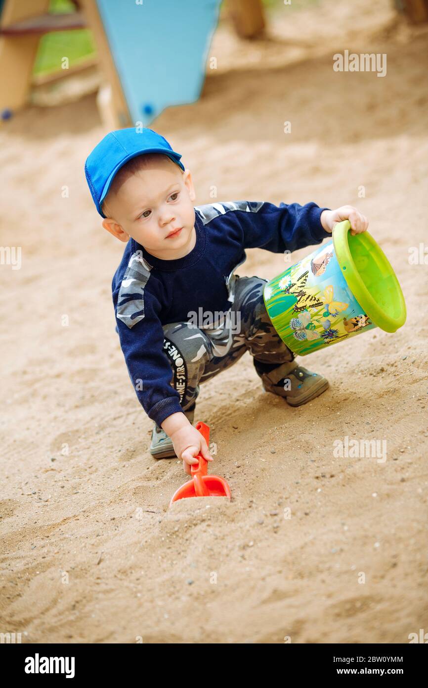 Ein Junge, 1-2 Jahre alt, gräbt ein Loch in den Sand Stockfoto