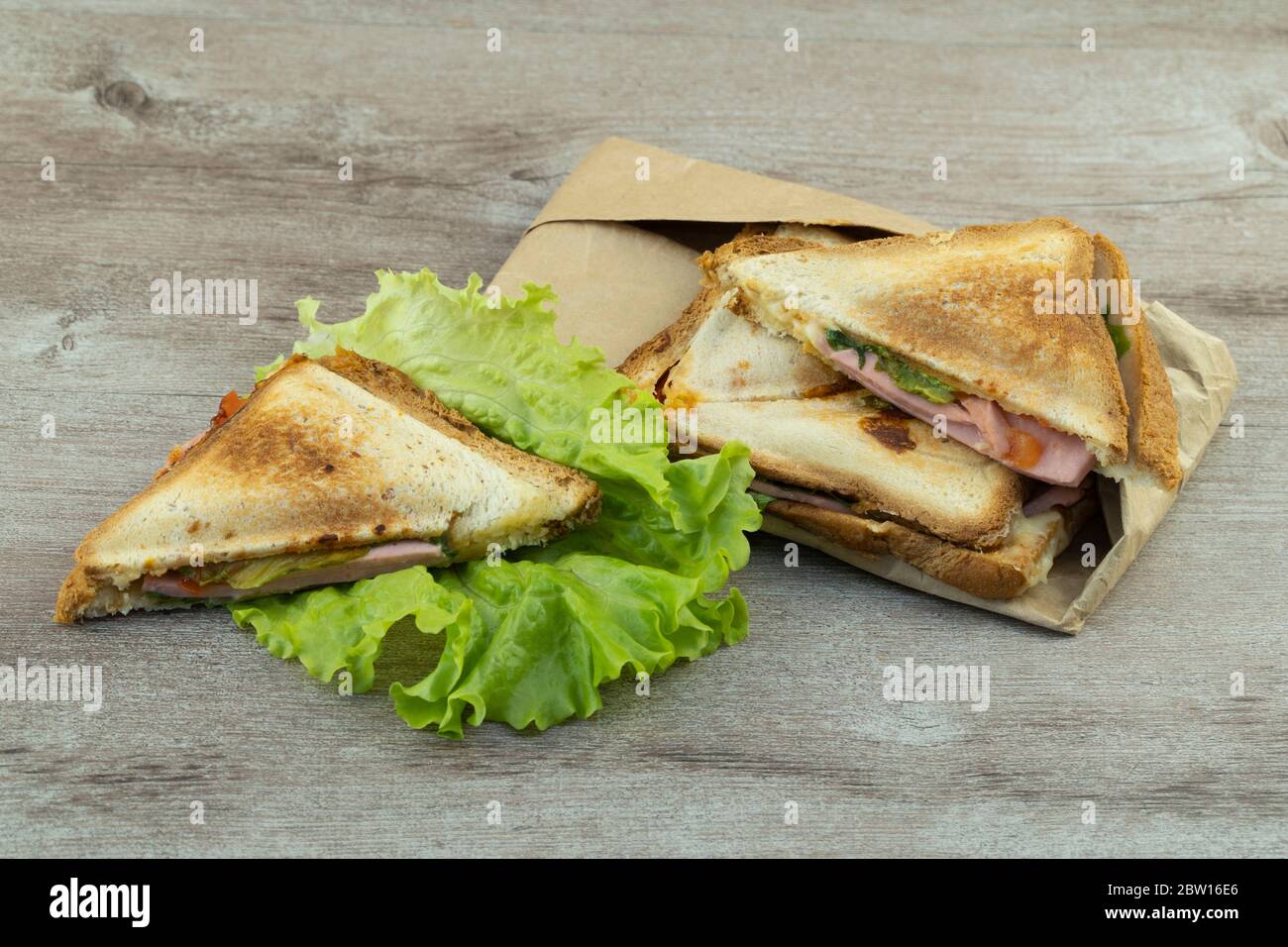 Warme Sandwiches zum Frühstück auf einem Holztisch. Konzept der schnellen und leckeren Speisen kochen. Stockfoto