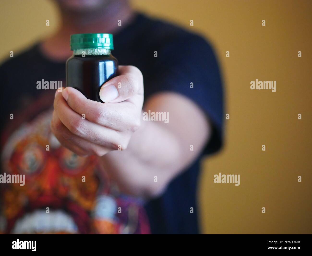 Ein Mann hält eine Flasche Essenz von Huhn. Nahrungsergänzungsmittel helfen, die Gesundheit zu erhalten. Stockfoto