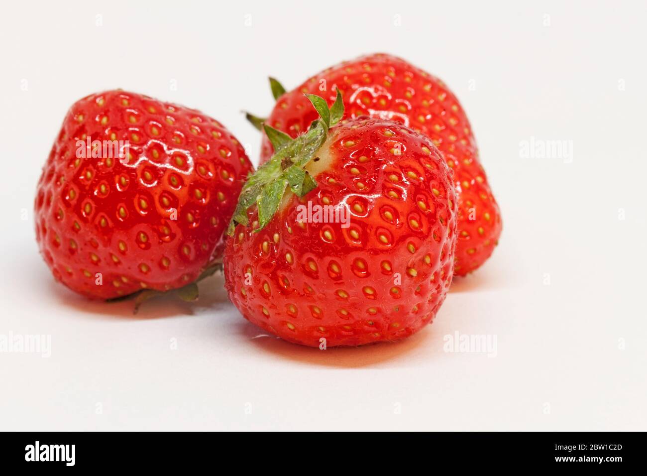 Drei saftige Erdbeeren auf weißem Hintergrund Stockfoto