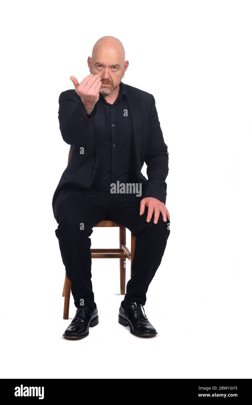 Kahlköpfiger Mann sitzt auf einem Stuhl, der sagt, geh zu ihm Stockfoto