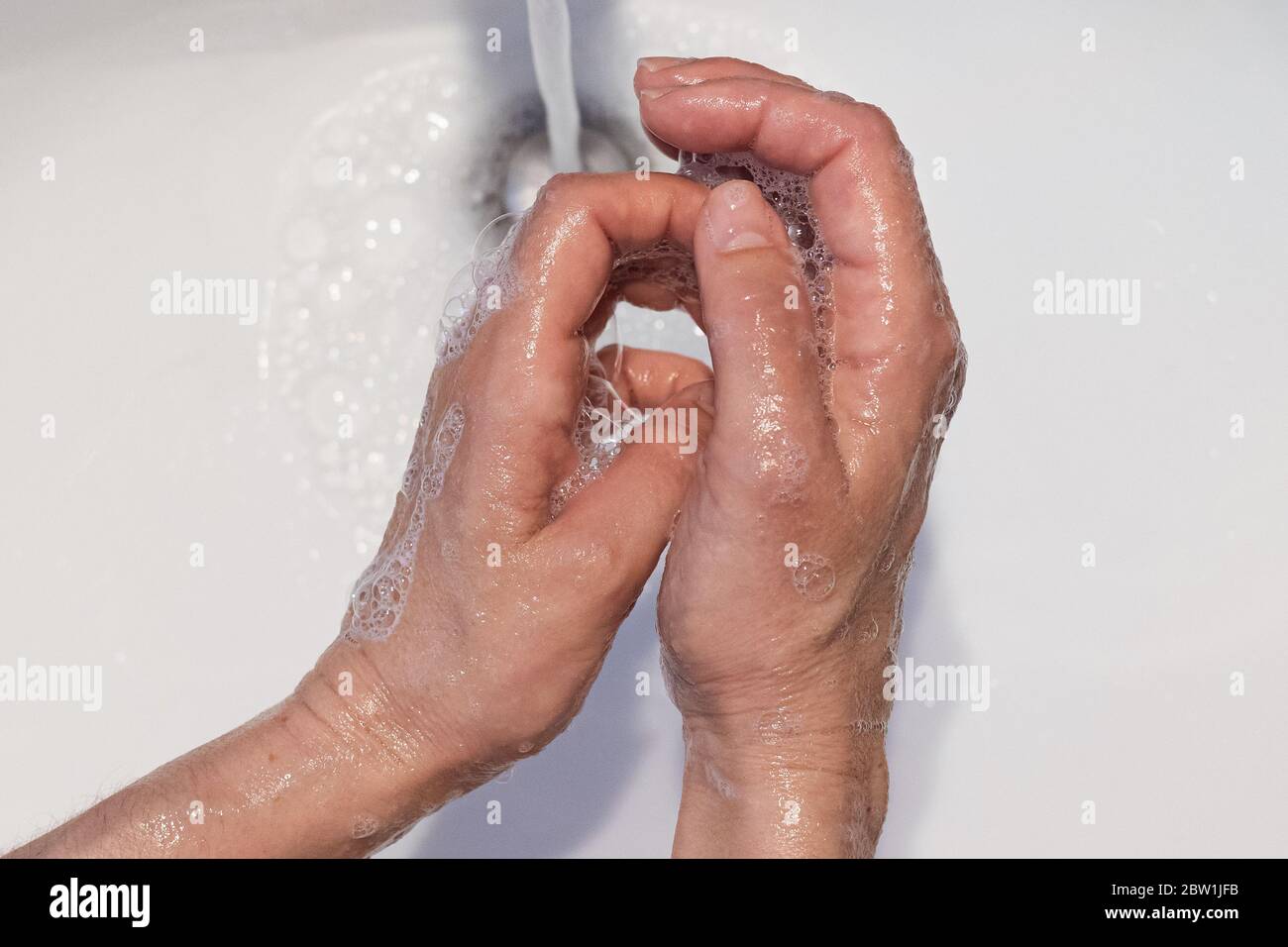Nahaufnahme der weiblichen Hände in einem weißen Waschbecken mit Seife gewaschen, Konzept der Gesundheitsversorgung, Prävention von Infektionen Stockfoto