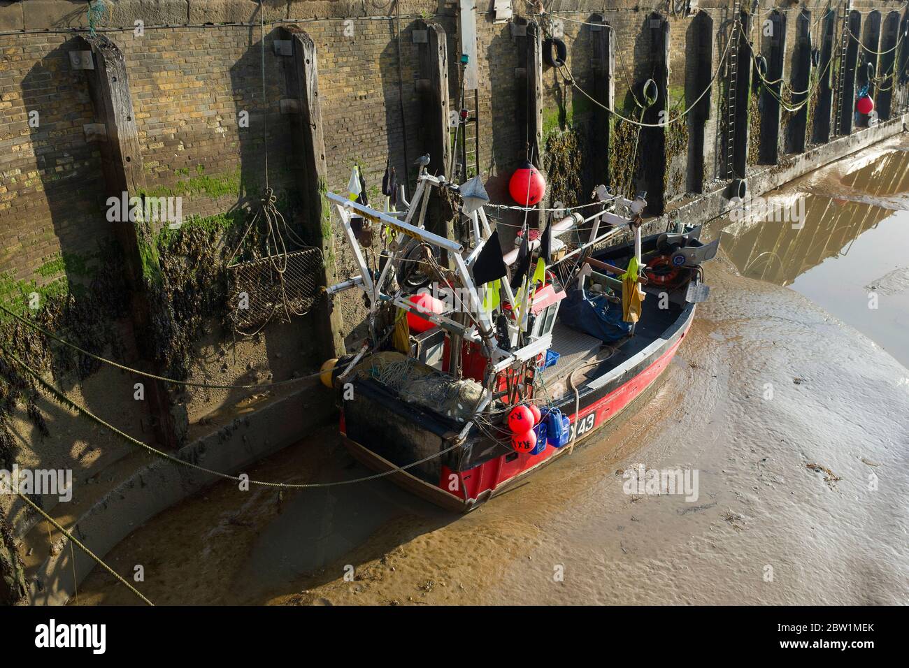 Britisches Fischerboot, das im trockenen Hafen von Whitstable festsaß, Kent Vereinigtes Königreich England. Stockfoto